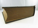 Fore-edge view of the age-toned text block and worn dark cloth binding.