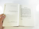 Brown cloth rear board and spine of the hardcover with the dust jacket partly lifted.