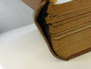 Close-up of a detached or weakened inner hinge with red-speckled page edges and separated text block.