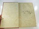 Red cloth cover of the other volume with blind-stamped border, rubbing, and wear along the spine joint.
