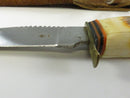 Close view of the brass crossguard, sawback spine, and handle spacers