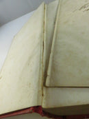 Close view of a gilt-decorated spine and page edges, with splitting cloth and wear at the joint.