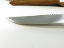 Close view of the unmarked side of the clip-point blade and sawback spine