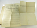 Close view of the loose lined-paper insert resting on a stained, wavy page.